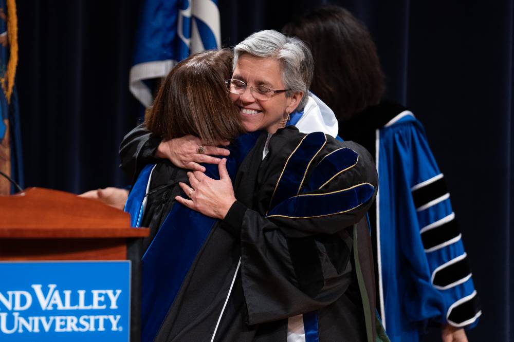 Provost and Faculty member hugging on stage